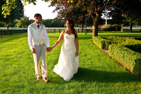 bride and groom walking through beautiful green landscape