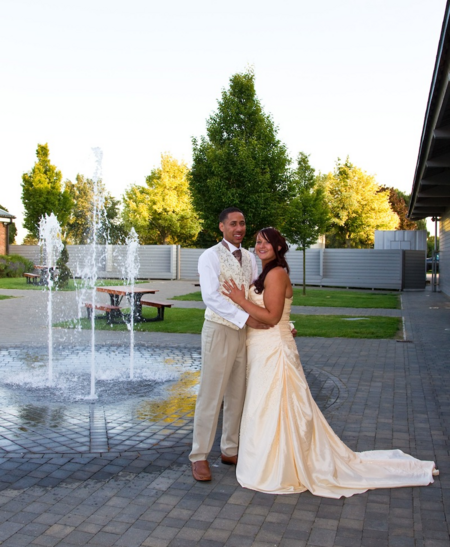 groom holding bride by fountain