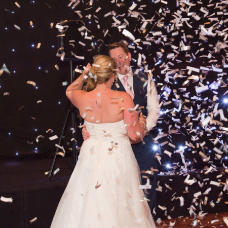 newlywed couple dancing in confetti